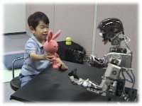 photo: A 4-year-old body showing a toy to Infanoid
